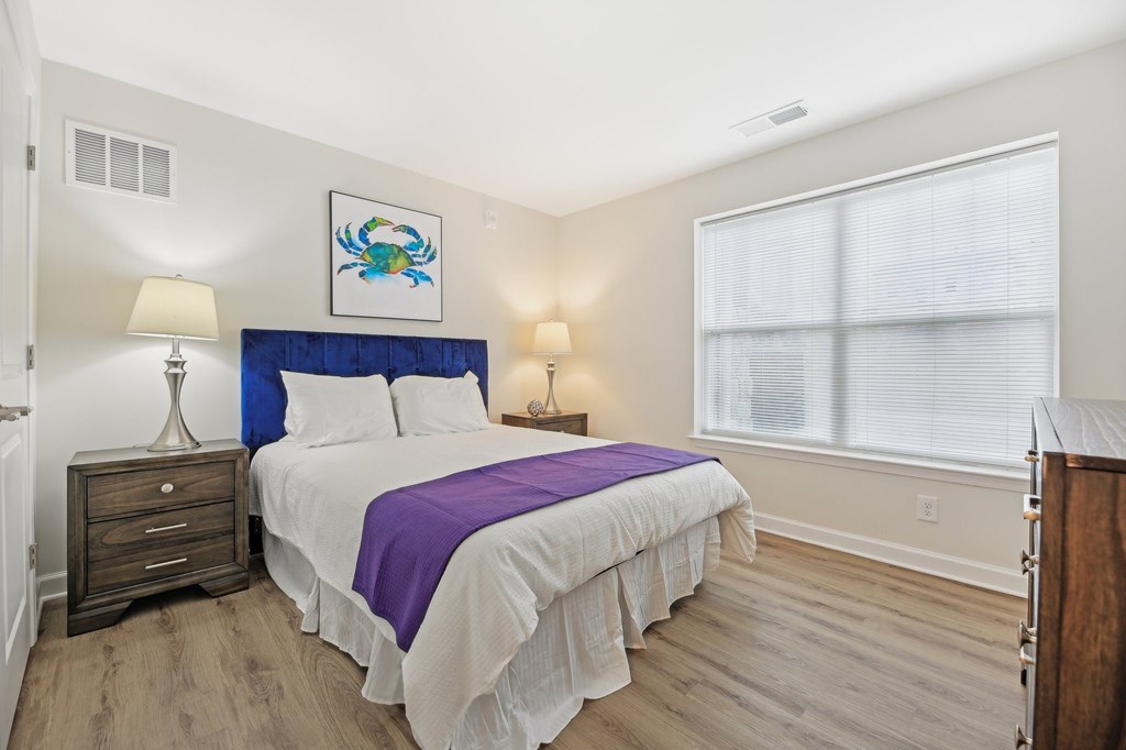 A bedroom with a bed, nightstand, and lamp.