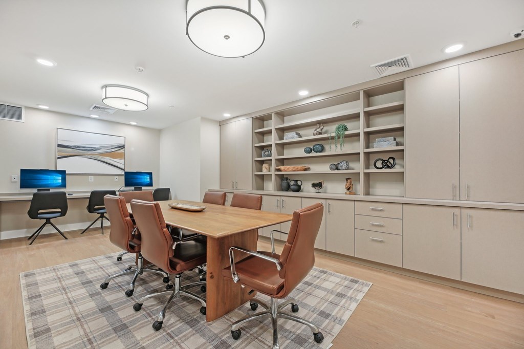 A conference room with a table, chairs, and a computer desk.