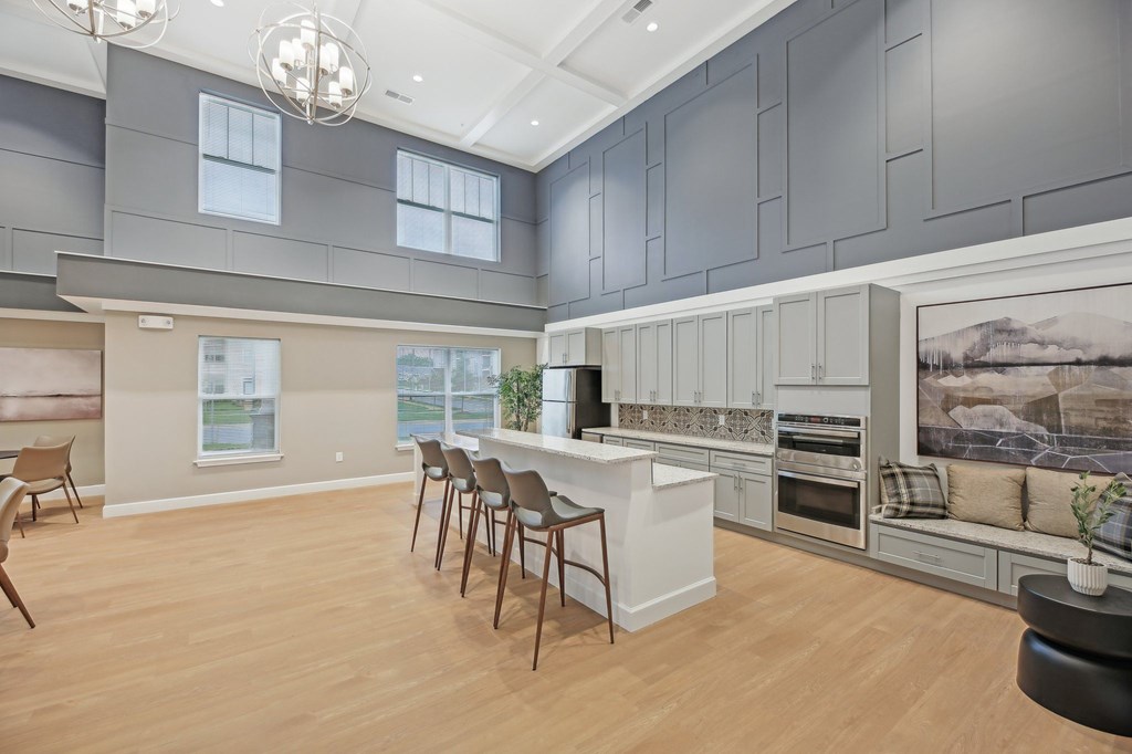 A kitchen with a large island and chairs.