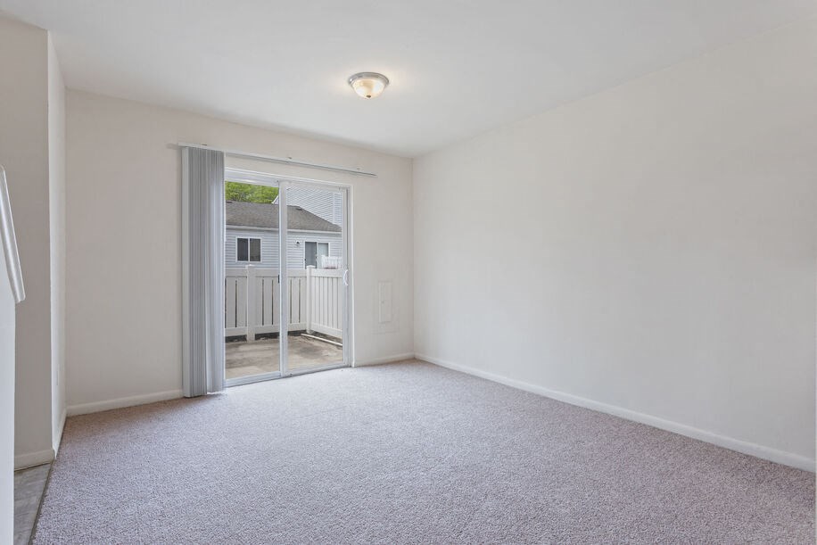 a bedroom with a sliding glass door leading to a balcony