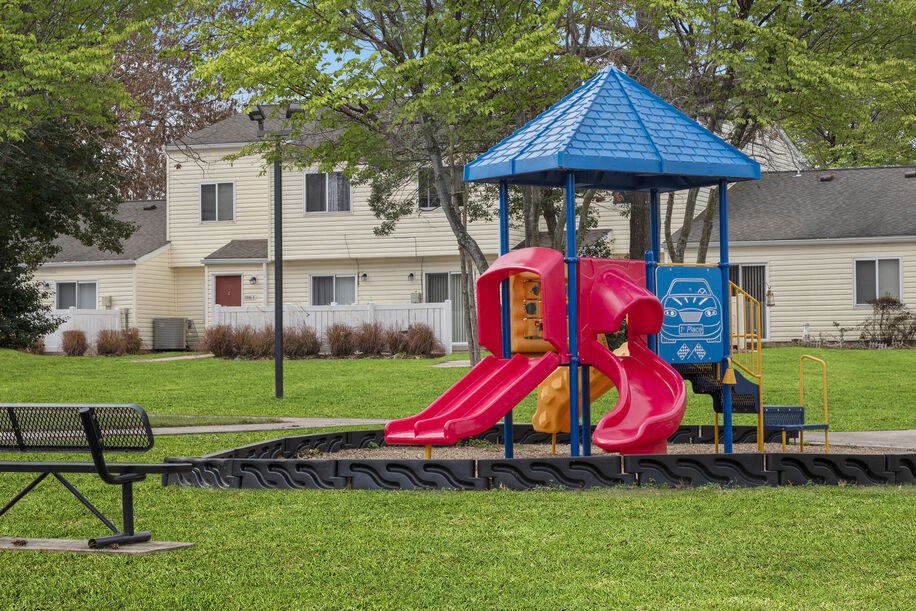 a playground with a pink slide and blue gazebo
