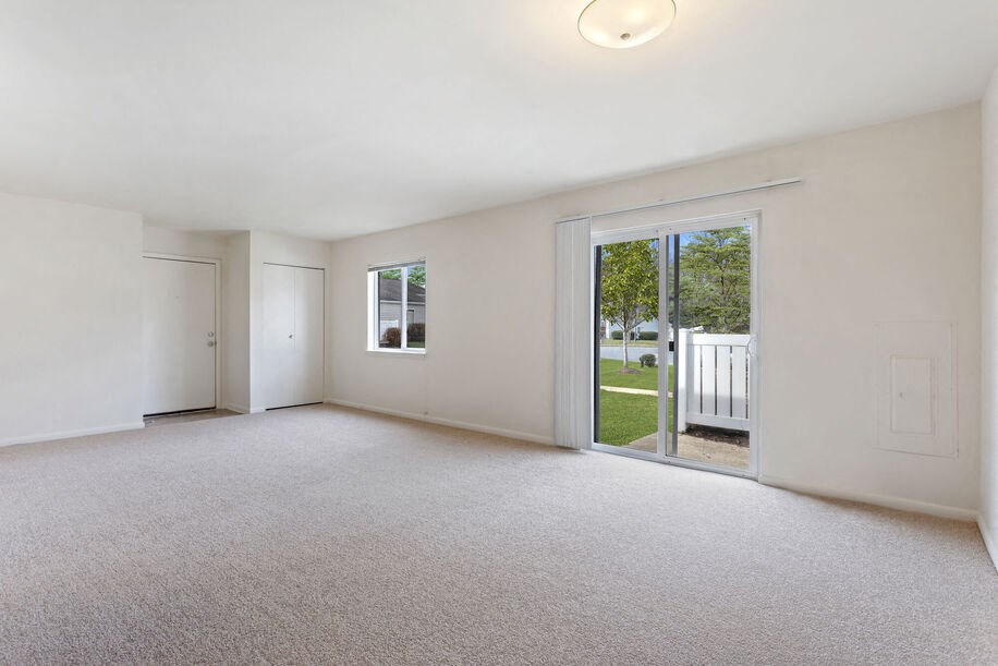 a bedroom with white walls and carpet
