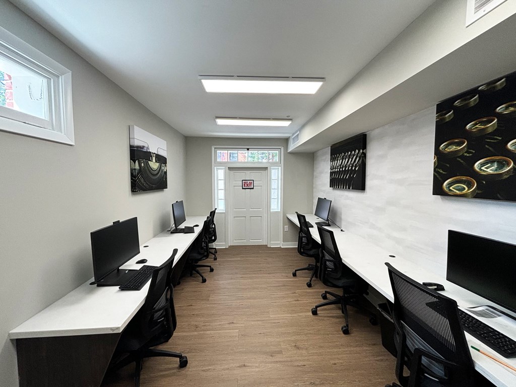 a computer room with desks and chairs and a door