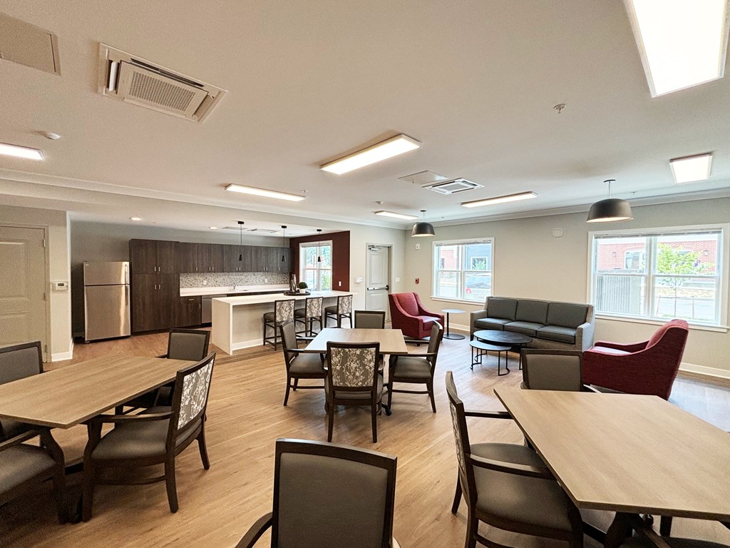 a dining room with tables and chairs and a kitchen