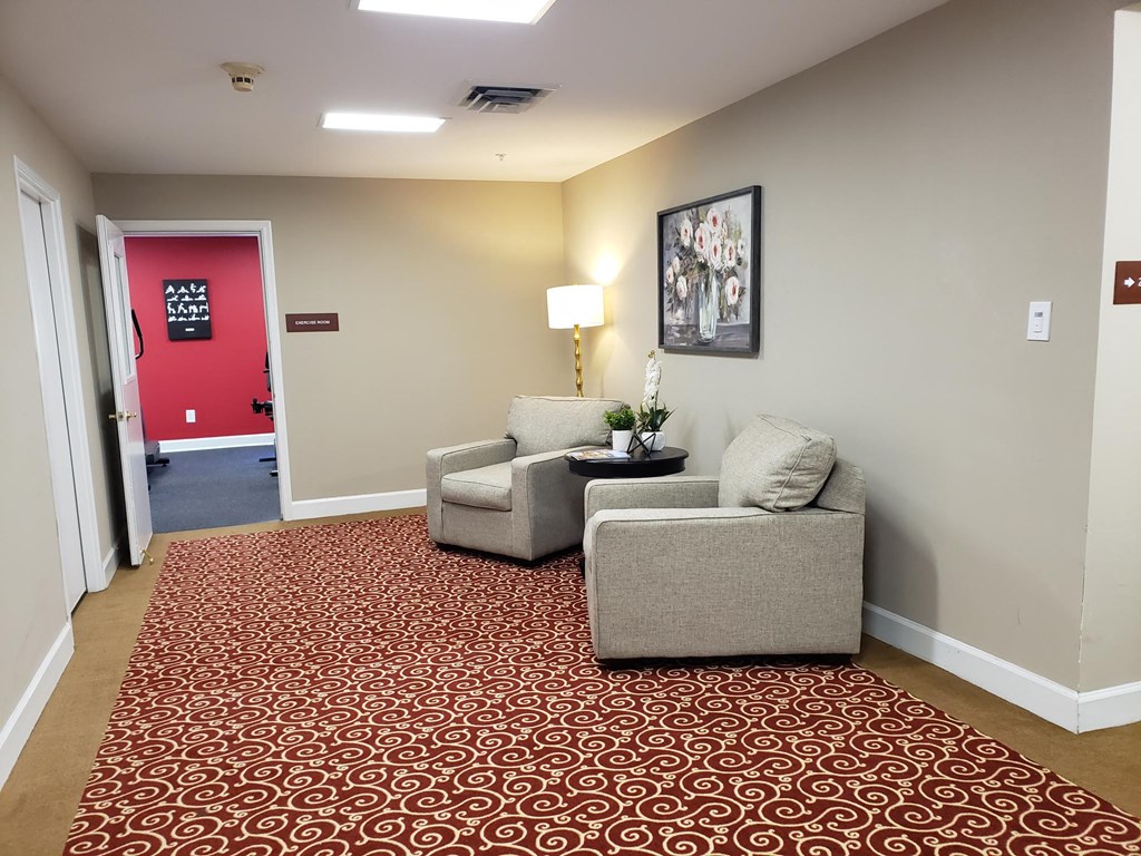 a room with two chairs and a table in front of a red door
