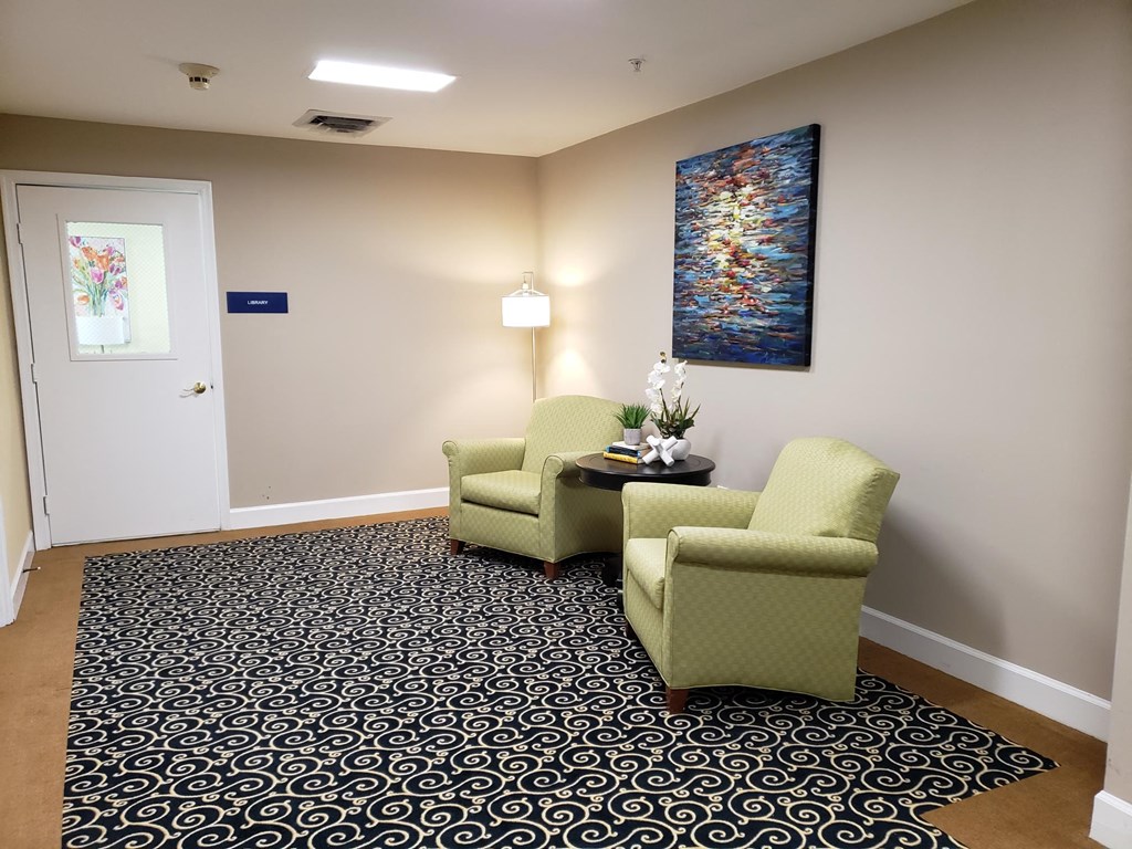 a room with two chairs and a table with a lamp