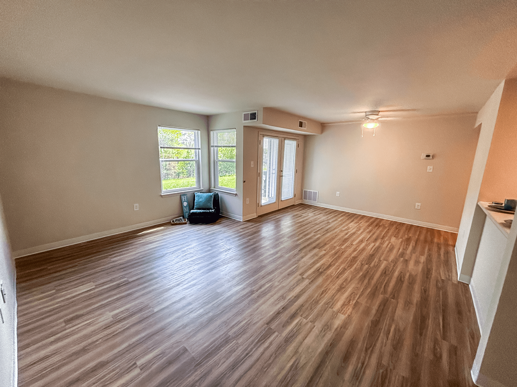 an empty living room with a hard wood floor