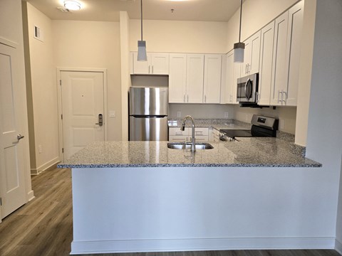 A kitchen with a granite countertop and stainless steel appliances.
