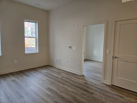A room with a wooden floor and a door on the right.