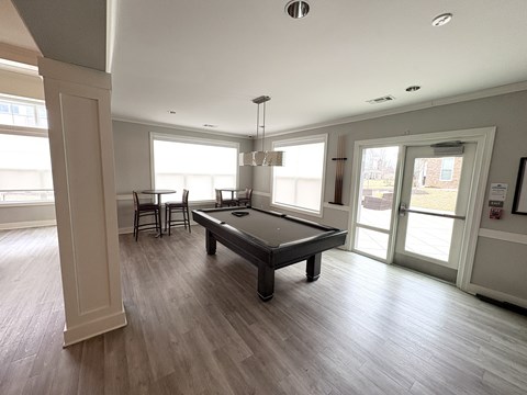 A spacious room with a pool table and a view of the outside.