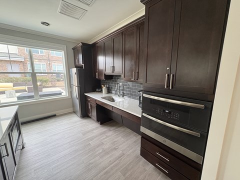 A kitchen with dark wood cabinets and a black oven.