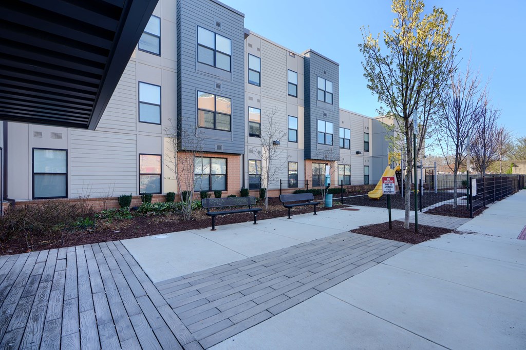 Apartment complex with a tree in front.