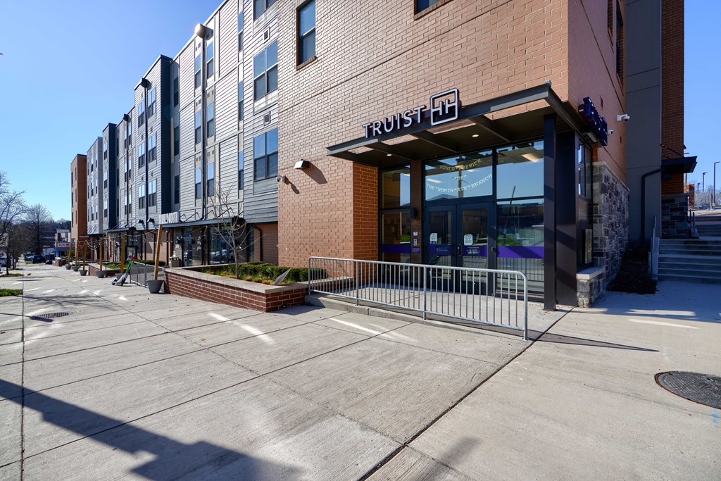 A brick building with a glass entrance and a sign that says "TRUIST H" is shown.