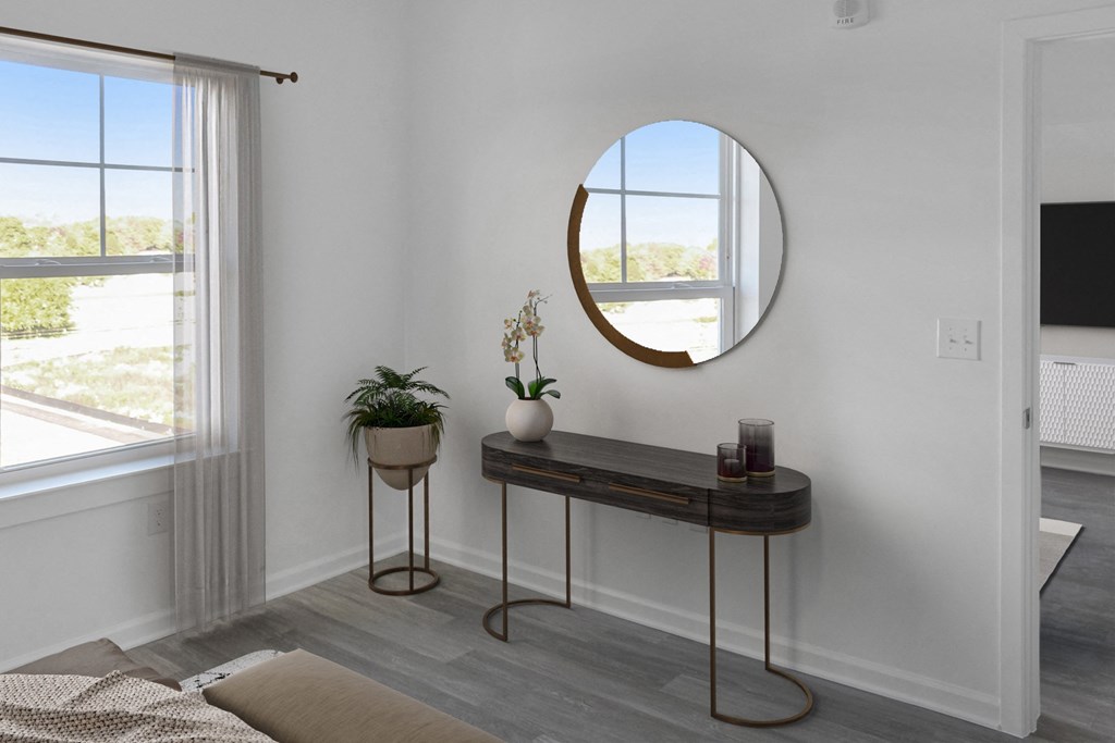 a living room with a round mirror and a table with a plant