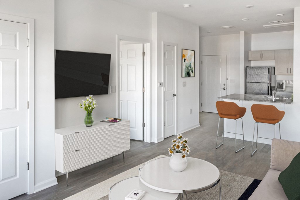 a living room with a table and chairs and a kitchen