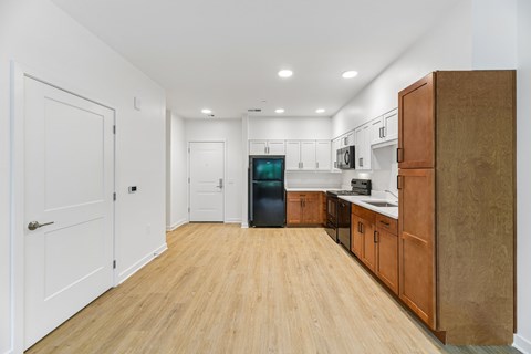 A kitchen with wooden floors and white walls.