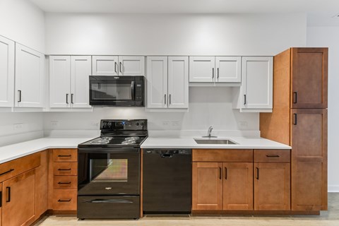 A kitchen with black appliances and wooden cabinets.