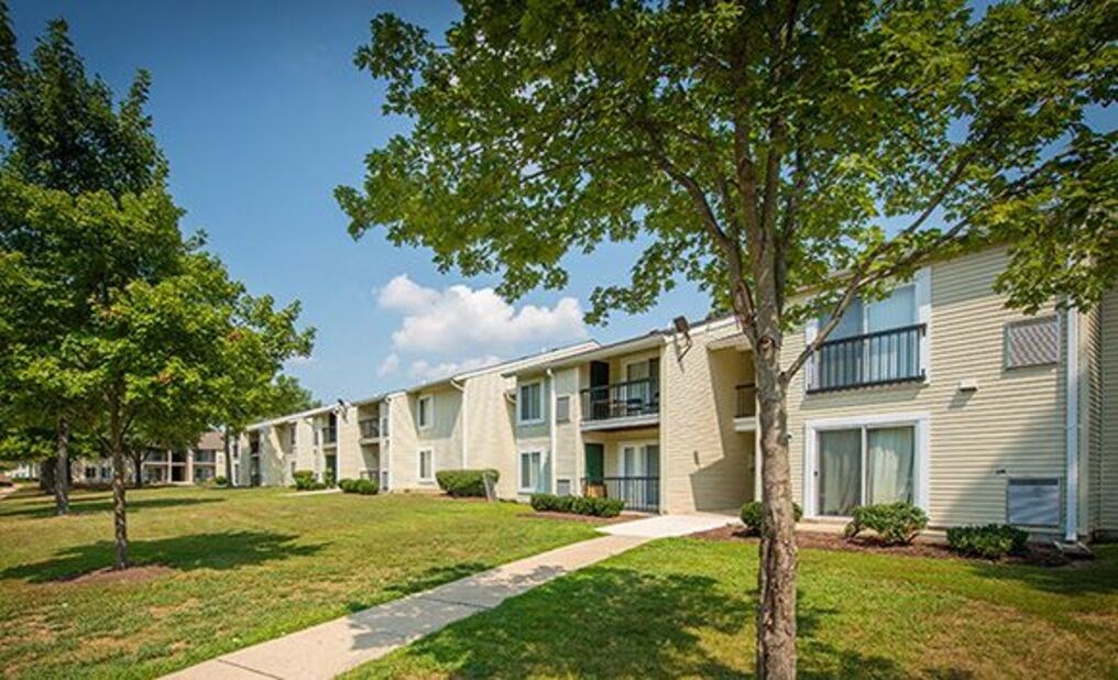 a picture of a building with a grassy area and trees