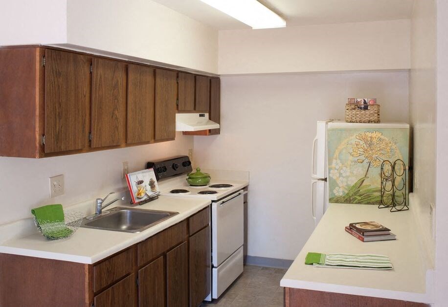 a kitchen with a white refrigerator freezer next to a stove top oven