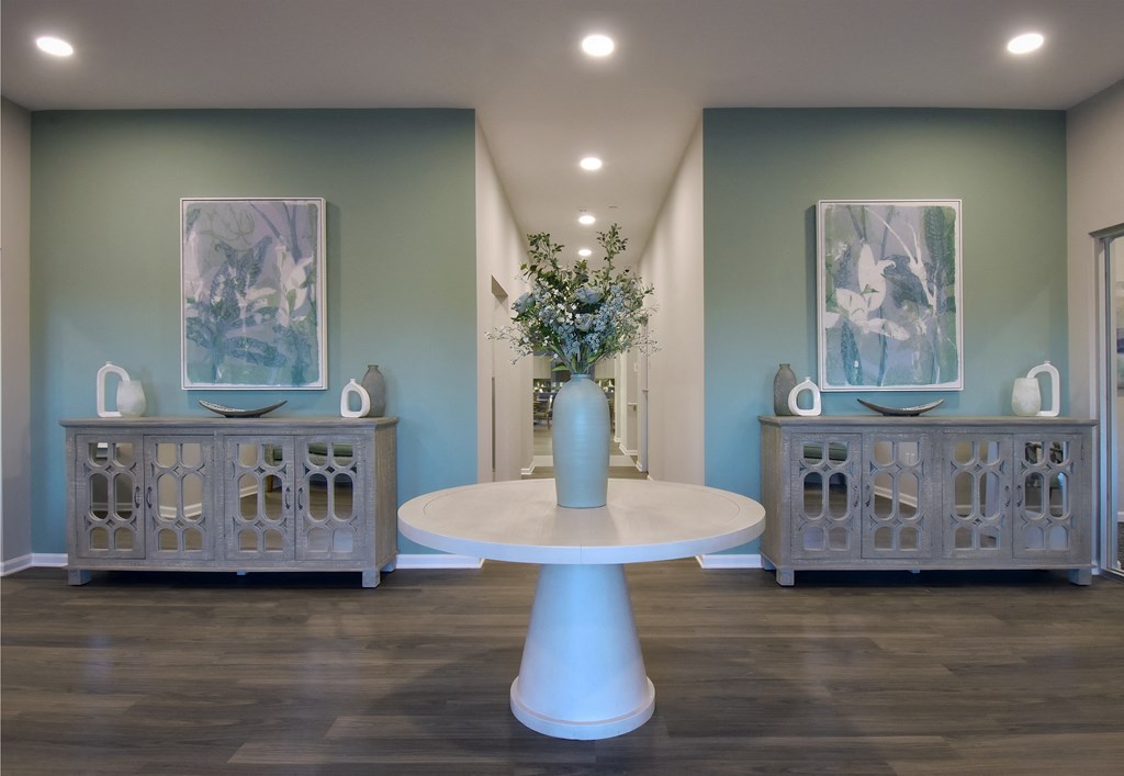a room with a white table and a vase with flowers