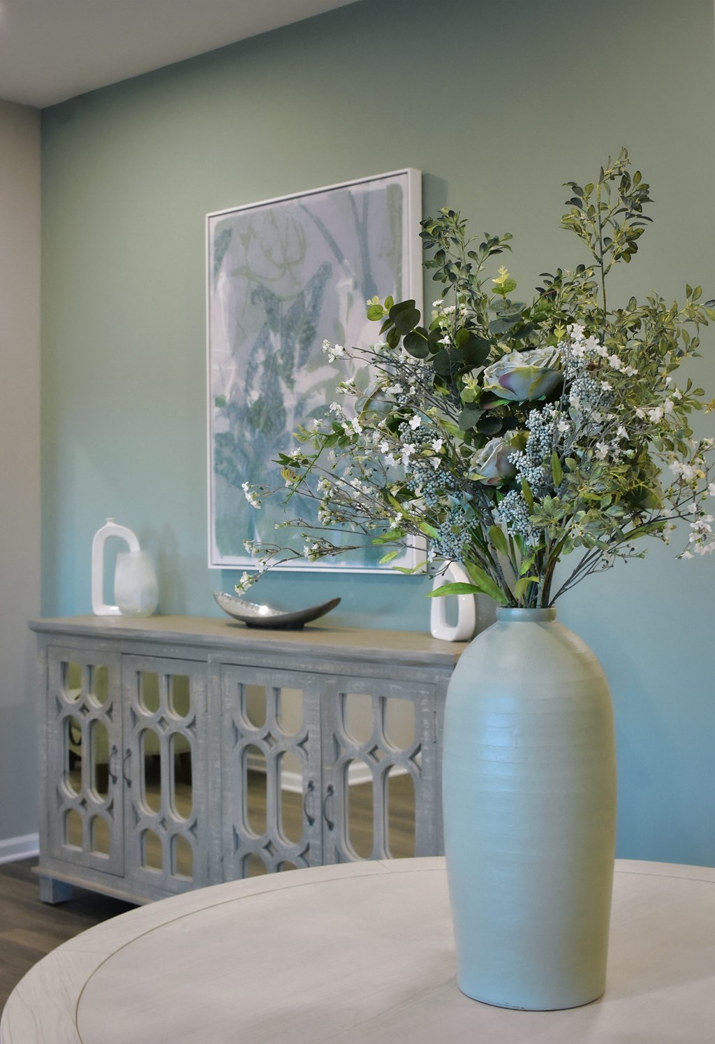 a blue vase with flowers on a table