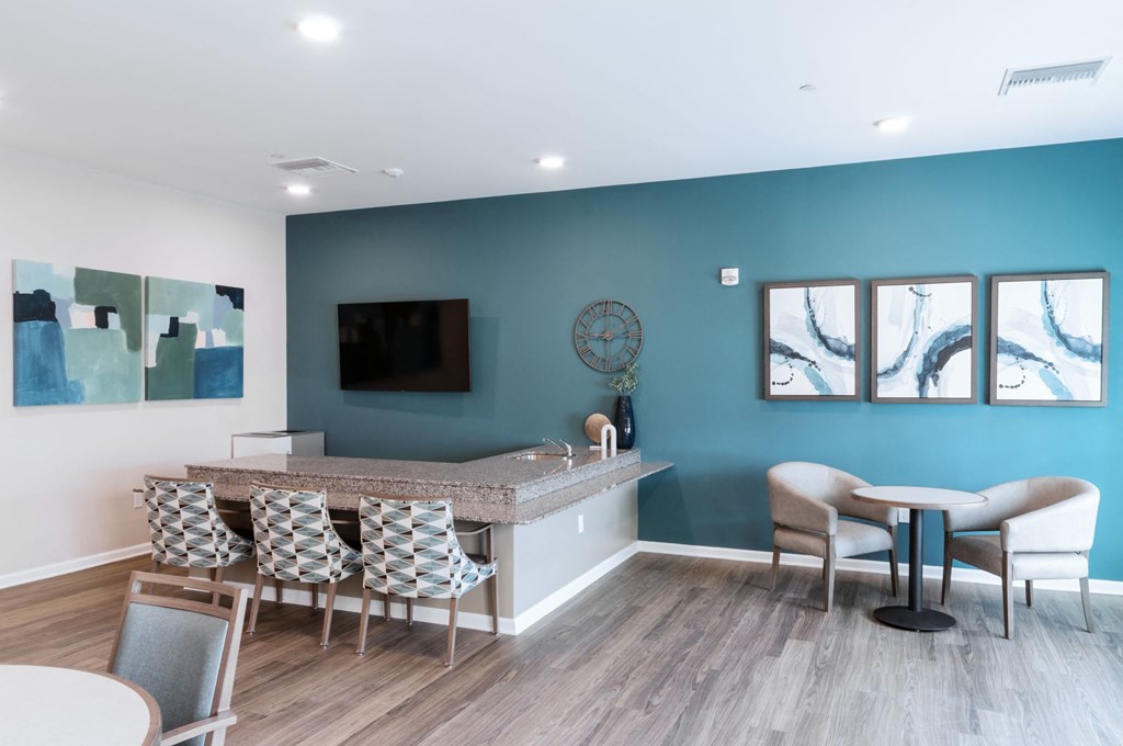 a waiting room with a bar and chairs and a television