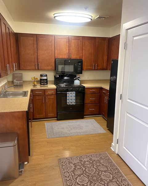 A kitchen with wooden cabinets and a black stove top oven.