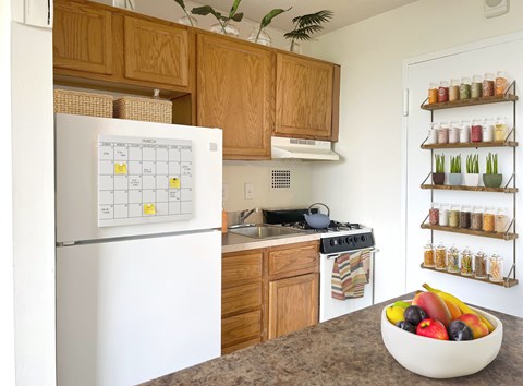 A white fridge with a calendar on it in a kitchen.