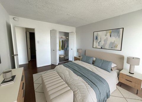 A bedroom with a large bed and a painting on the wall.