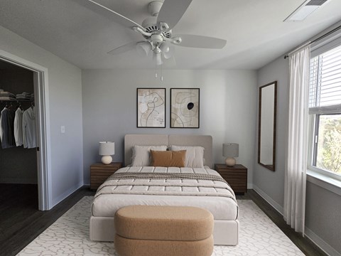 A bedroom with a large bed and a ceiling fan.