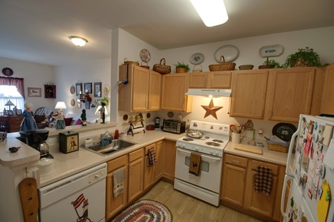 a kitchen with white appliances and wooden cabinets