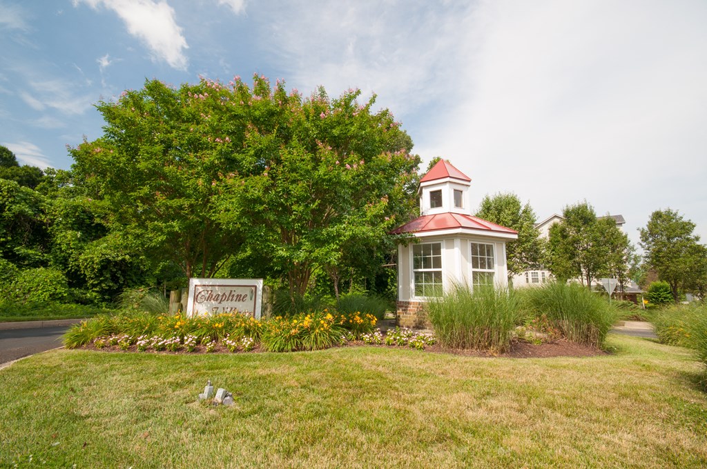 a garden in front of a building with a sign