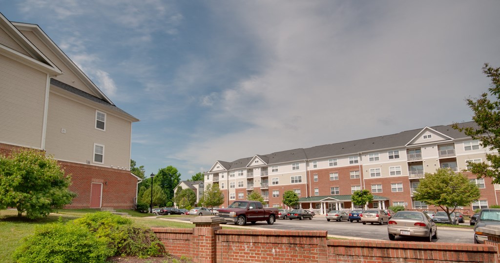a parking lot with cars in front of an apartment building