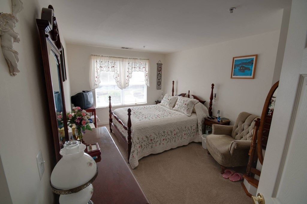 a bedroom with a bed and a dresser and a window