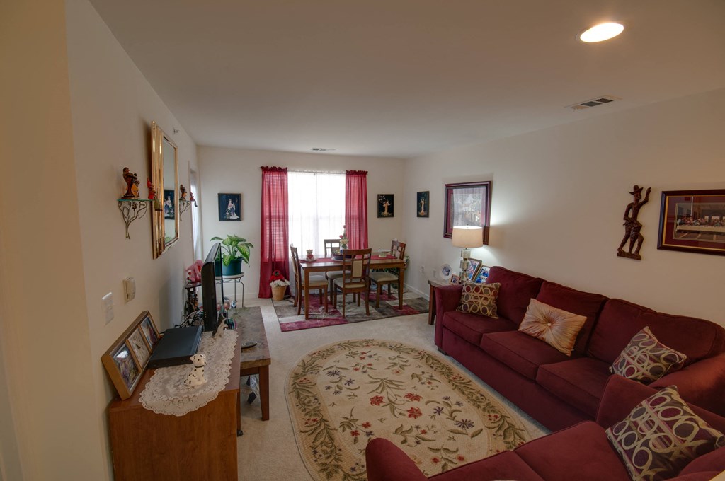 a living room with a red couch and a dining room table