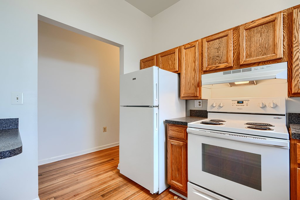A kitchen with a white refrigerator and white stove.