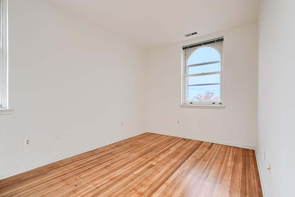 A room with wooden flooring and a window.