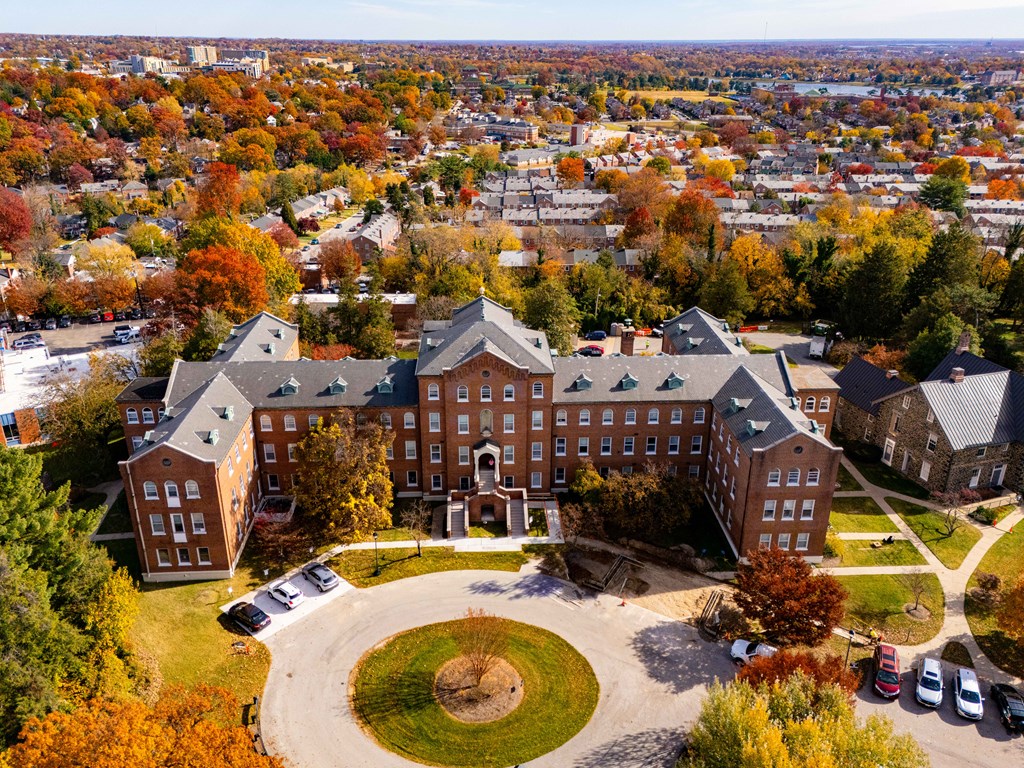 A large red brick building with a green lawn in front.