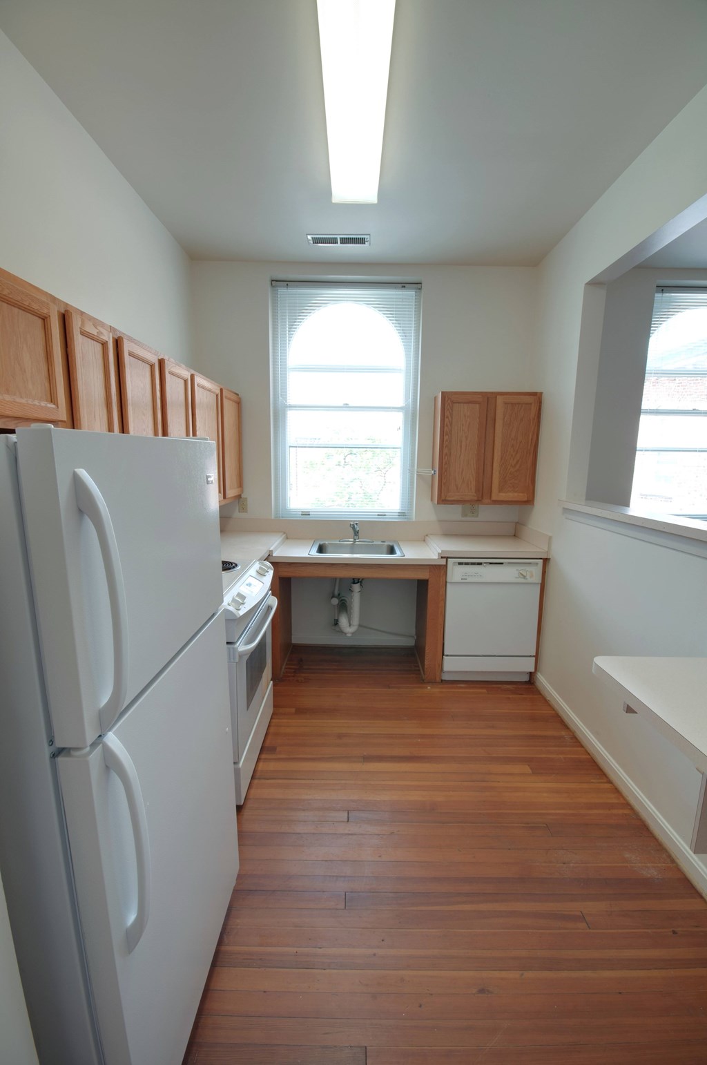 A kitchen with a white fridge and wooden cabinets.