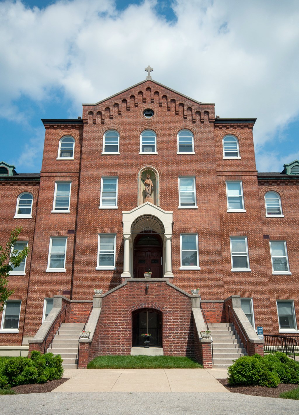 A red brick building with a statue on the front door.