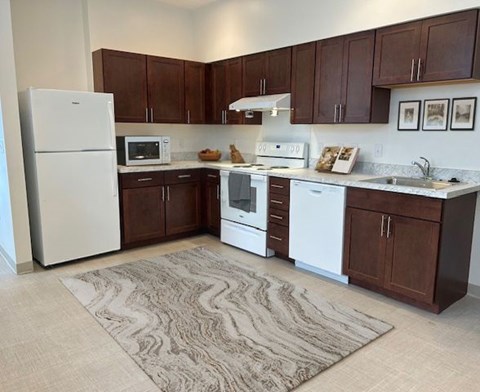 A kitchen with brown cabinets and white appliances.