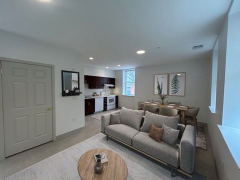 A living room with a grey couch and a wooden coffee table.