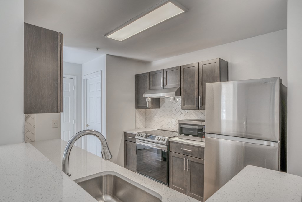 a kitchen with stainless steel appliances and a white counter top