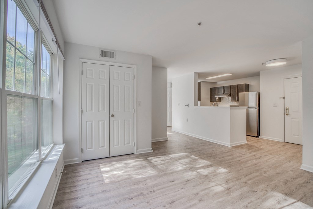 an empty living room and kitchen with a large window