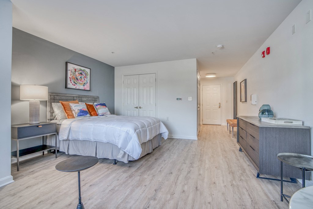 a bedroom with a bed and a dresser and a bathroom