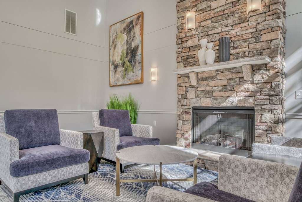 a living room with a fireplace and chairs and a table