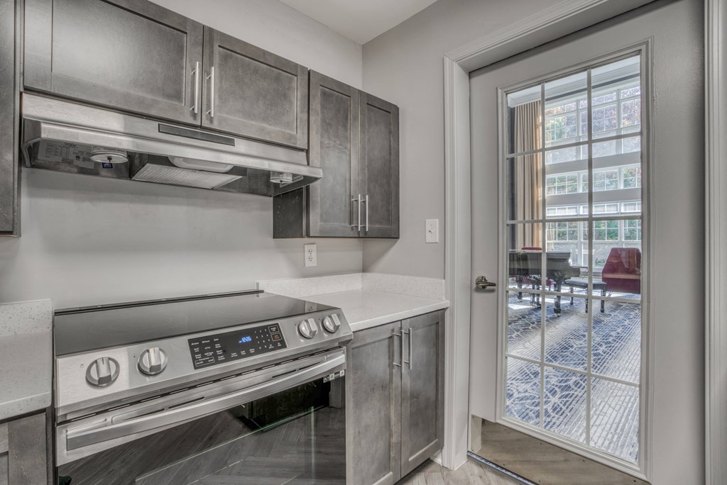 a kitchen with stainless steel appliances and a door to a patio