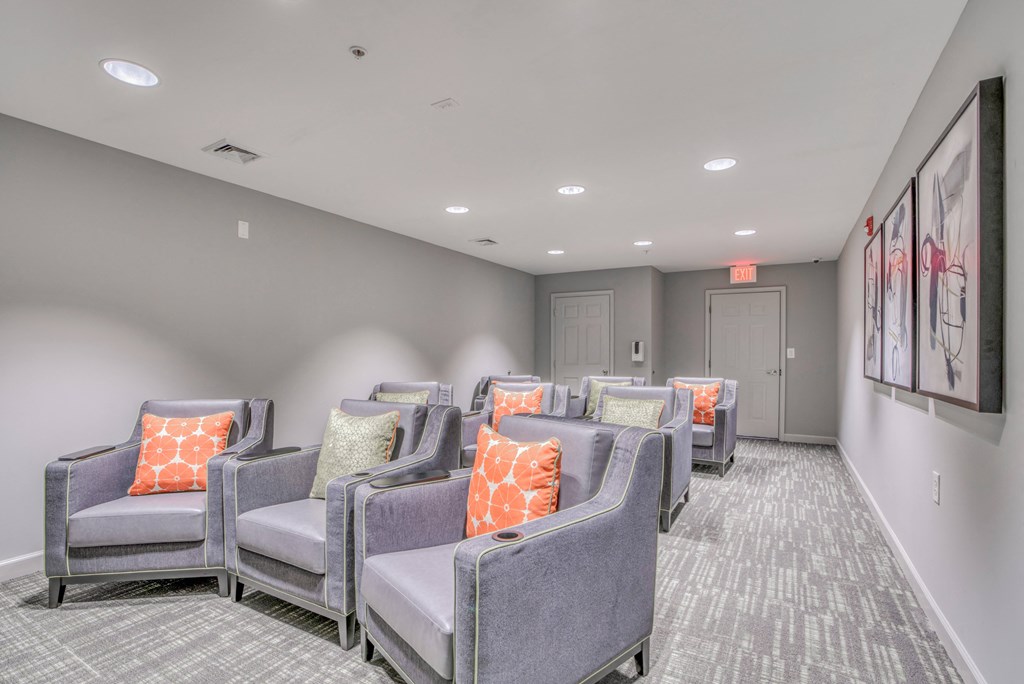 a community room with chairs and couches and a door