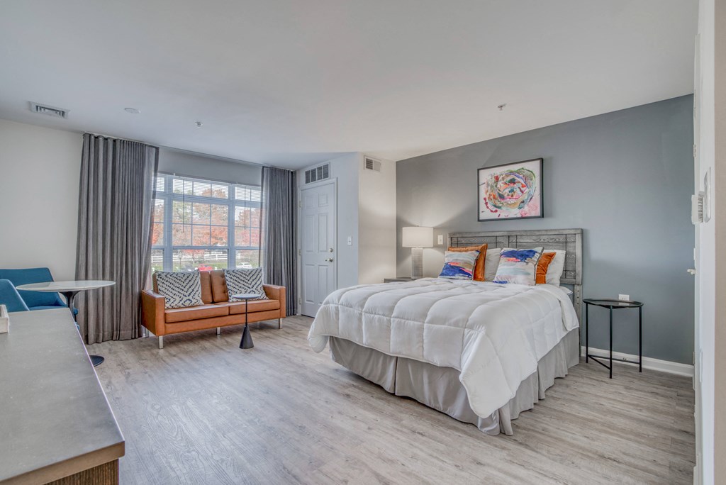 a bedroom with a bed and a couch and a window