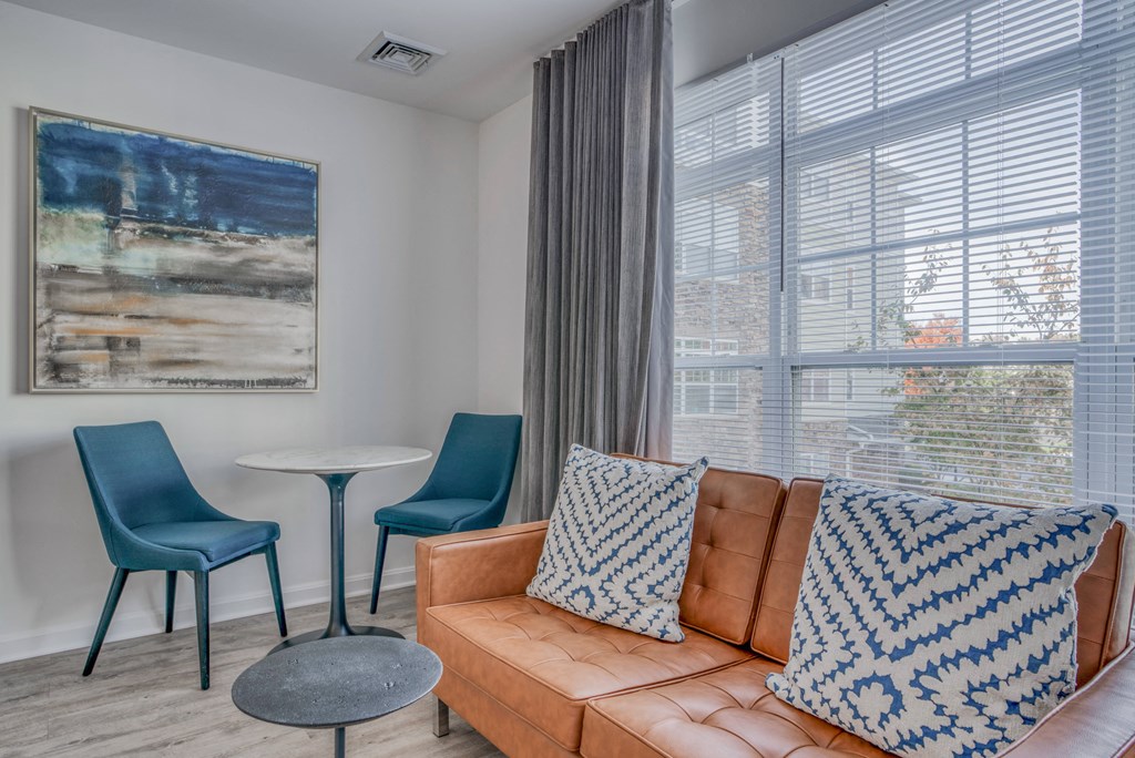 a living room with a couch and two chairs and a table